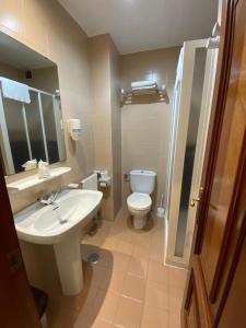 a bathroom with a white sink and a toilet at Hotel Chiquín in Tapia de Casariego +26 photos