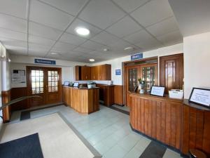 a waiting room with wooden cabinets and a counter in at Hotel Chiquín in Tapia de Casariego