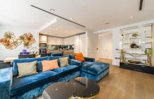 a living room with a blue couch and a kitchen at Chancery Quarters - 124 Chancery Lane in London