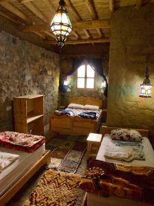 Cette grande chambre comprend deux lits et une fenêtre. dans l'établissement Chambres dans casbah - Gite D'étape Gorges De Ziz, à Errachidia