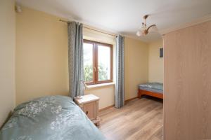 Schlafzimmer mit einem Bett und einem Fenster in der Unterkunft Apartament Albatros 75m z ogródkiem in Warschau