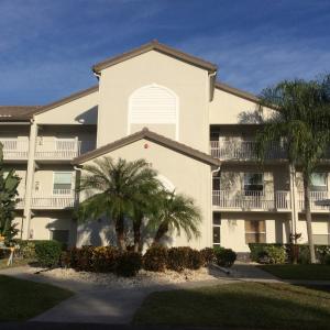 um grande edifício com palmeiras em frente em Florida Vacation Condo em Sarasota