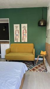 Eilat charming & cozy Studio في إيلات: غرفة معيشة مع أريكة وجدار أخضر