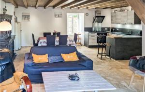 sala de estar con sofá azul y cocina en 2 Bedroom Lovely Home In Saint-just-luzac, en Saint-Just