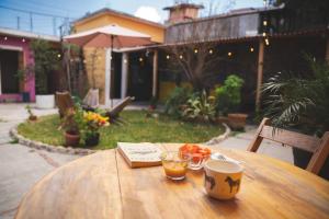 a wooden table with a cup of coffee and fruit on it at Casa Sofia Guest House in San Cristóbal de Las Casas