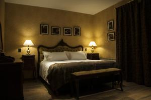 a bedroom with a large bed with two lamps on the wall at Hotel City Bell in La Plata