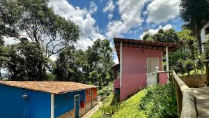 a small house with a blue and pink at Sensorial Macacos in Macacos