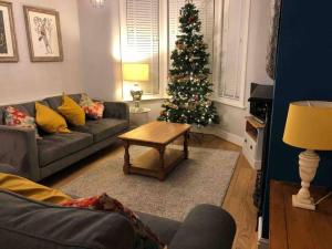uma sala de estar com uma árvore de Natal e um sofá em Gloucester Rd 2 mins away - Fab, new, trendy house em Bristol