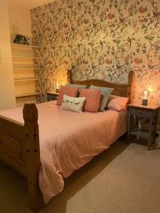 um quarto com uma cama de madeira e papel de parede floral em Gloucester Rd 2 mins away - Fab, new, trendy house em Bristol