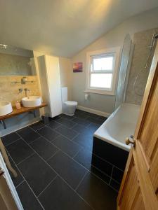 a bathroom with two sinks and a tub and a toilet at Gloucester Rd 2 mins away - Fab, new, trendy house in Bristol