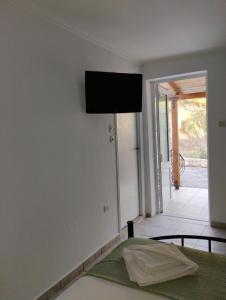 Zimmer mit einem Bett und einem TV an der Wand in der Unterkunft Studios Dimitraki in Skala Rachoniou