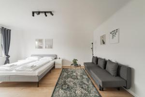 een witte slaapkamer met een bed en een bank bij Homely apartment - 10 minutes to Stephansplatz in Wenen
