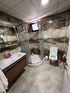 a bathroom with a shower and a sink and a toilet at Otel Sweet Home in Atakum