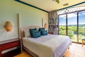 ein Schlafzimmer mit einem Bett und einem großen Fenster in der Unterkunft Bougainvillea 7315 Luxury Penthouse Adults Only - Reserva Conchal in Playa Conchal