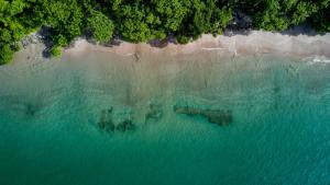 eine Luftansicht auf einen Strand und das Meer in der Unterkunft Bougainvillea 7315 Luxury Penthouse Adults Only - Reserva Conchal in Playa Conchal