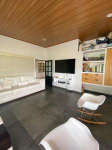 een woonkamer met witte meubels en een flatscreen-tv bij Casa Finca Soluna in Cumaral