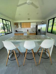 een keuken met een aanrecht met 3 stoelen en een tafel bij Casa Finca Soluna in Cumaral