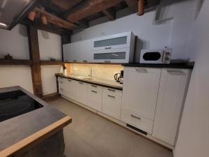 a kitchen with white cabinets and a sink and a microwave at Ferienhaus Drakenhof in Bad Salzuflen