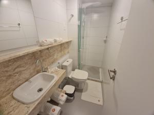 a bathroom with a sink and a toilet and a shower at PUERTO VENTURA Cabo Branco Flat in João Pessoa +14 photos