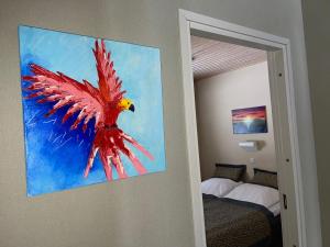 a painting of a bird hanging on a wall in a bedroom at Imatra Kylpyla Spa Entire Apartment in Imatra