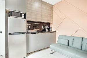 a kitchen with a refrigerator and a blue couch at Elegant1BR Apartment with Stunning Renovations in Miami L08A in Tamiami