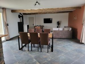 a dining room with a table and chairs and a couch at gite de l'écurie in Saint-Samson