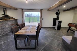 comedor con mesa, sillas y chimenea en gite de l'écurie en Saint-Samson