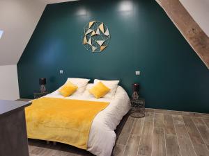 a bedroom with a large bed with a green wall at gite de l'écurie in Saint-Samson