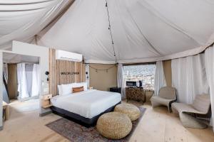 a bedroom in a tent with a bed and chairs at Zion Wildflower Resort in Virgin +37 photos