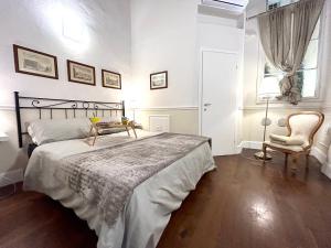 フィレンツェにあるSanto Spirito Suiteのベッドルーム1室(ベッド1台、椅子、窓付)