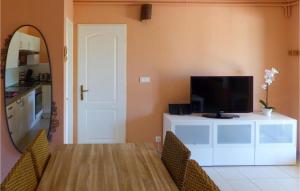 een woonkamer met een televisie en een tafel met stoelen bij Cozy Home In Rayol-canadel-sur-mer With Wifi in Rayol-Canadel-sur-Mer