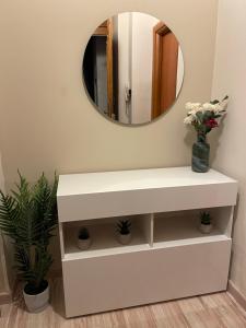 uma cómoda branca na casa de banho com um espelho em Mazzini Apartment em Cosenza