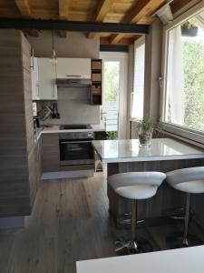 eine Küche mit einer Theke und Stühlen in der Unterkunft Note di lago in Manerba del Garda