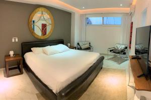 1 dormitorio con 1 cama blanca grande y espejo en New Zona Romantica beautiful Sunsets private Spa, en Puerto Vallarta
