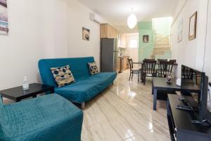 a living room with a blue couch and a kitchen at Family Villas in Vourvourou