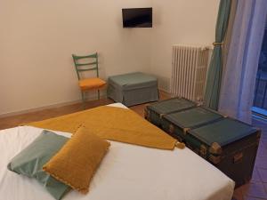 1 dormitorio con 1 cama, 1 silla y 1 maleta en Riscatto 1514, en Matera