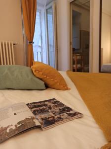 a book sitting on top of a bed with a pillow at Riscatto 1514 in Matera