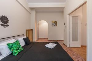 - une chambre avec un grand lit et une couverture noire dans l'établissement Pink Flat Exarcheia Athens Netflix, à Athènes