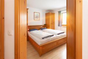 um quarto com uma cama com uma estrutura em madeira em Kurbad und Landhaus Siass em Bad Kohlgrub