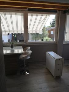 ein Büro mit einem Schreibtisch, einem Stuhl und 2 Fenstern in der Unterkunft Note di lago in Manerba del Garda