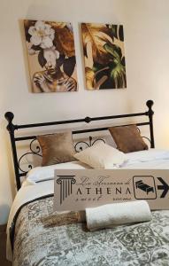 1 dormitorio con 1 cama con 3 cuadros en la pared en La Terrazza Di Athena sweet rooms, en Agrigento