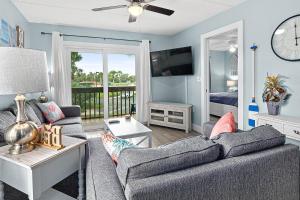 a living room with a couch and a bed and a clock at Welcome to paradise unit 2201 in Saint Augustine Beach