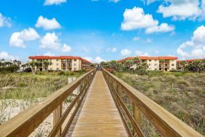 a wooden bridge over the beach with buildings in the background at Welcome to paradise unit 2201 in Saint Augustine Beach