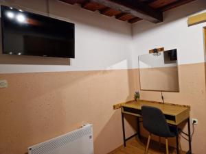 Cette chambre dispose d'un bureau et d'une télévision murale. dans l'établissement Juliana House, 