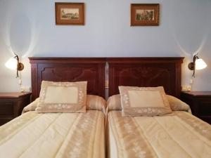 - une chambre avec 2 lits et des oreillers dans l'établissement Complejo rural Mirador del Condado, à Castellar de Santisteban