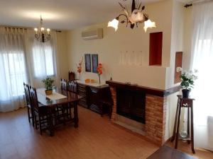 - un salon avec une table et une cheminée dans l'établissement Complejo rural Mirador del Condado, à Castellar de Santisteban