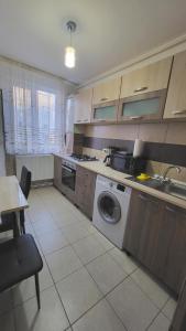 a kitchen with a sink and a washing machine at Apartament NAVI in Onești +19 photos