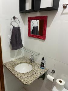 a bathroom with a sink and a red mirror at Vivendas do Serrano Apart105 Lençois in Lençóis