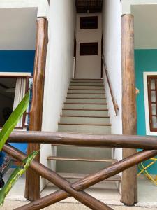 a staircase in a building with wooden railing at Vivendas do Serrano Apart105 Lençois in Lençóis