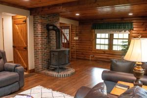a living room with a brick fireplace and a stove at Maple Leaf Cabin in Millersburg